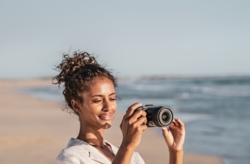 woman using a Sony A6400 on the beach