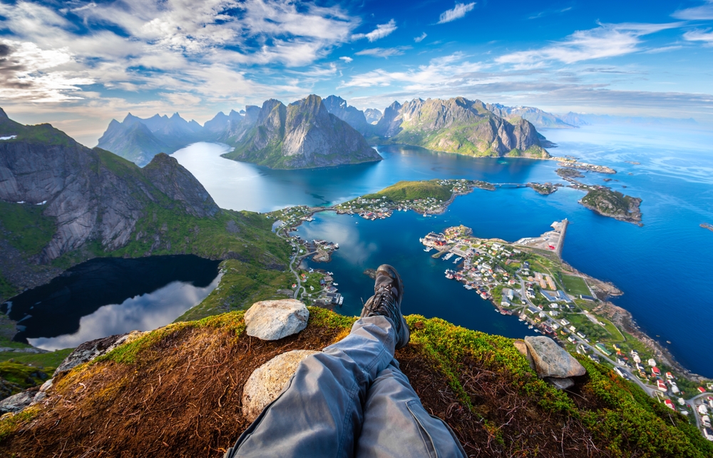 a hiker sitting at the edge of a cliff taking a selfie of their boots