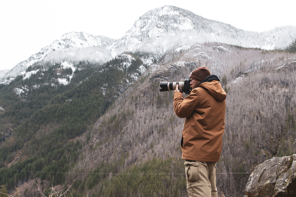 A photographer taking pictures in winter mountains