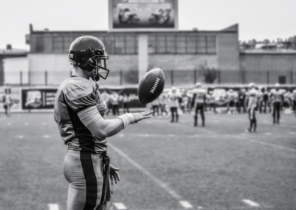American Football player playing with a football