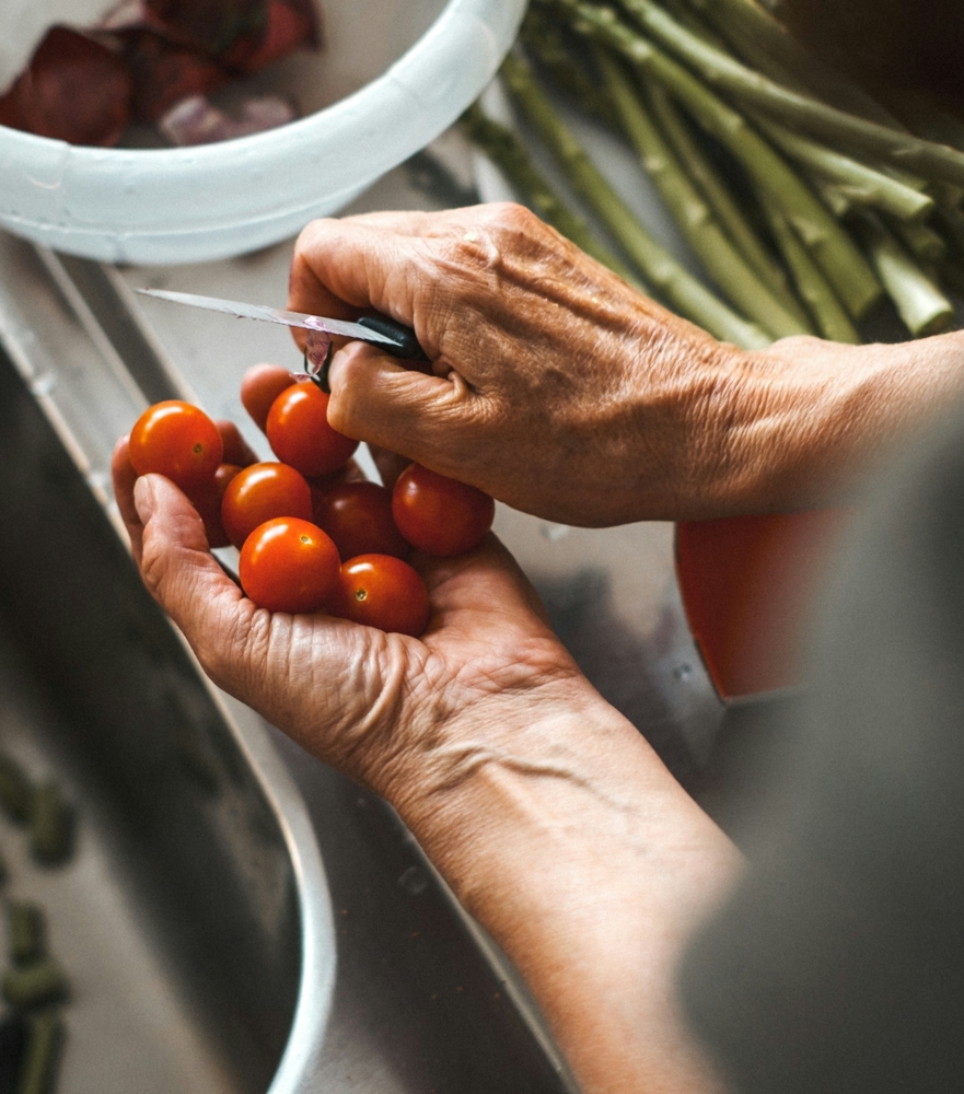 Hands with cherry tomatoes and a knife