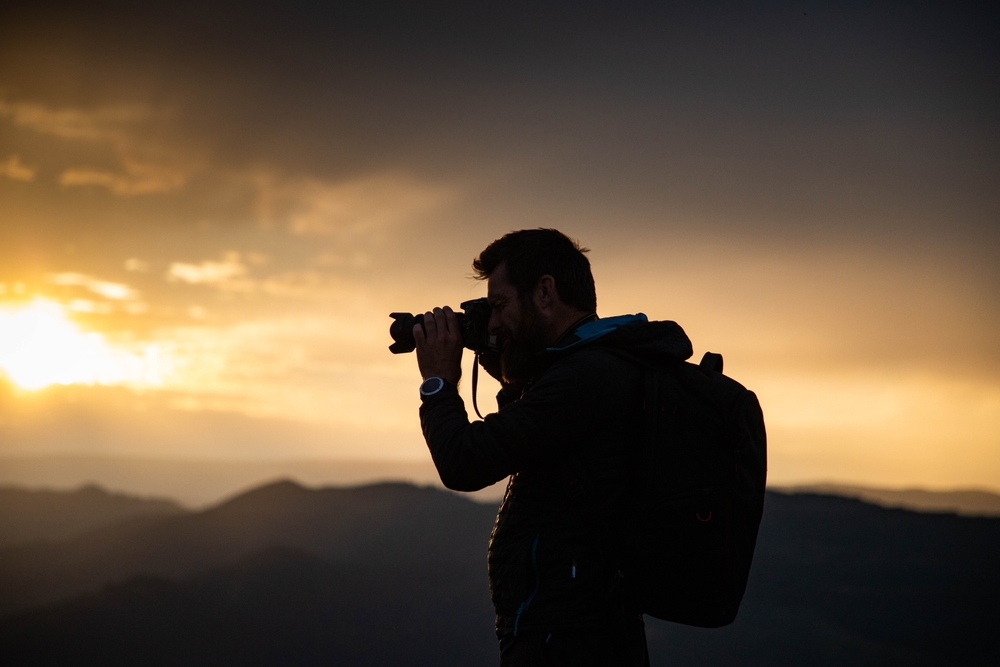 male photographer in nature at sunset