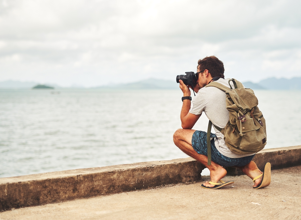 Man taking photos by the sea