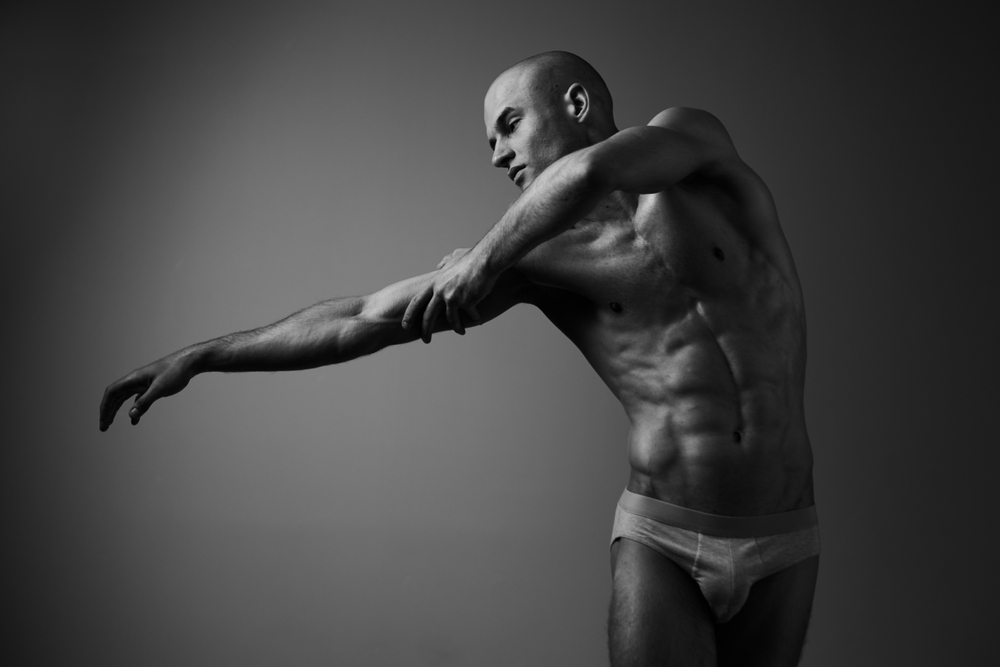 Nude Muscular man reaching to the side