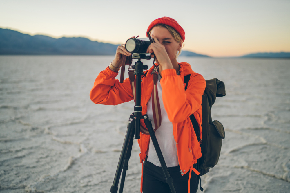 photographer using tripod shooting a scenic landscape in the desert