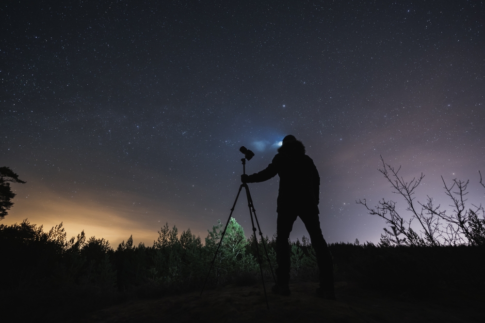 photographer with headlamp and tripod at night