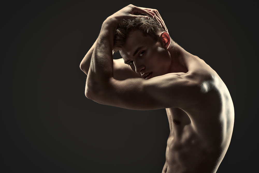 side view of a nude man looking at the camera