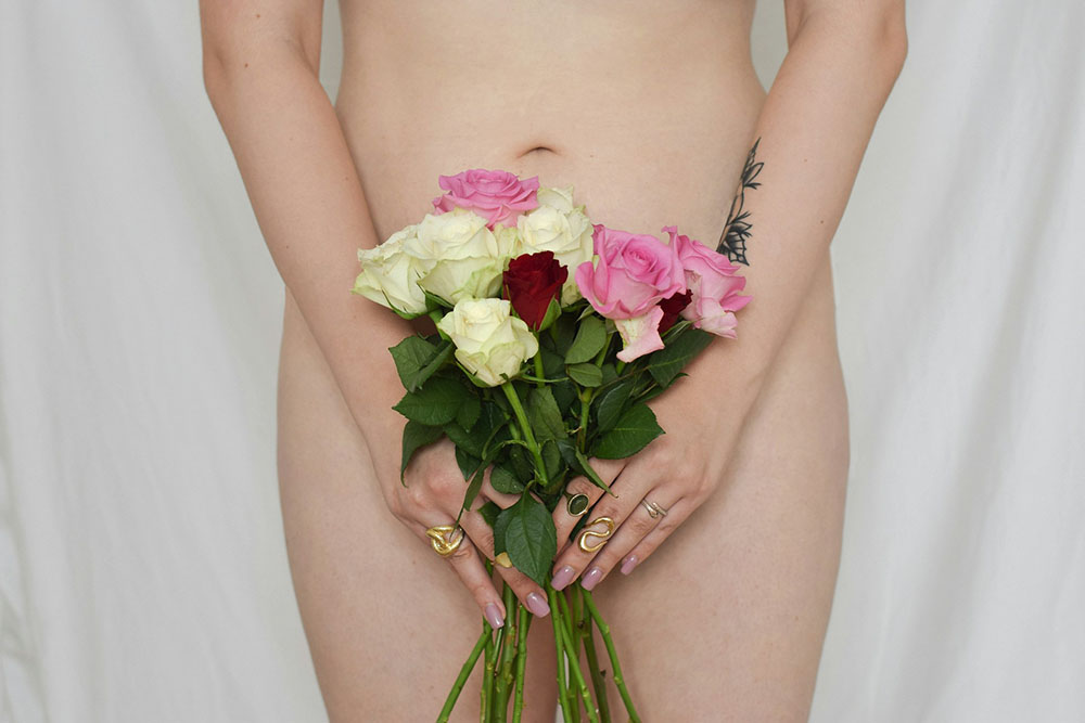 woman posing nude with flowers