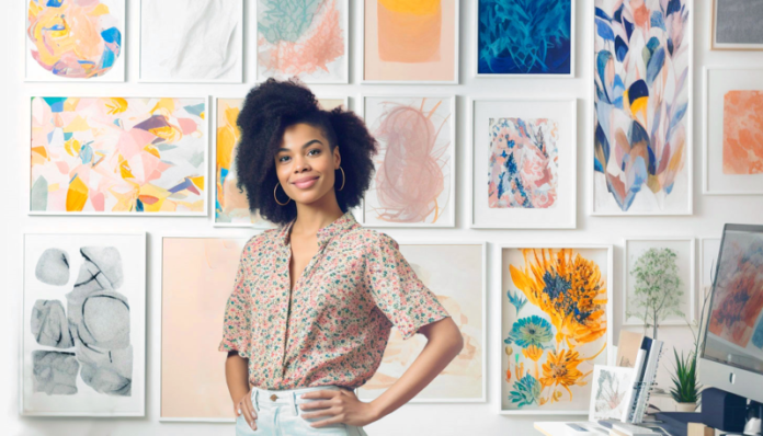 Woman standing in front of prints of her work